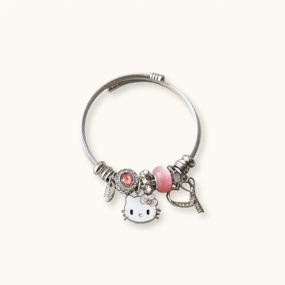 Silver cable bracelet adorned with a hello kitty charm, pink bead, and heart-shaped key pendant.